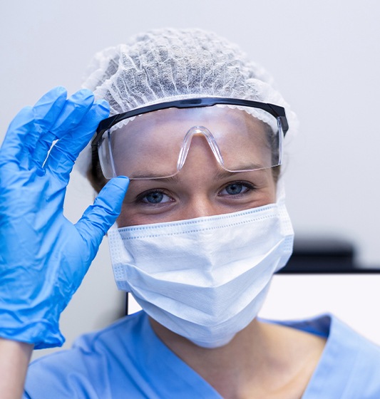 Dental team member putting on protective gear