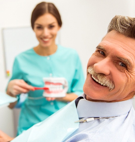 patient smiling after getting dentures in Pea Ridge