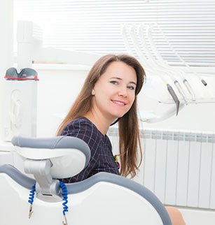 Woman smiling while sitting in dental chair