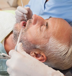 Older man laid back in dental chair during exam