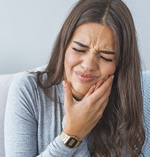 Woman with toothache holding cheek