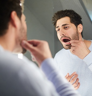 Man with lost dental crown looking at his smile