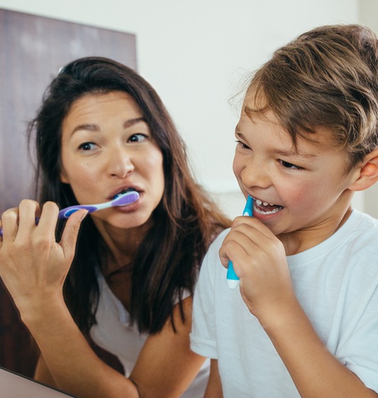 Mother and child brushing teeth to prevent dental emergencies