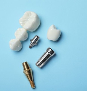 Dental implants, abutments, and restorations against blue background