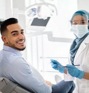 Happy dental patient smiling over his shoulder