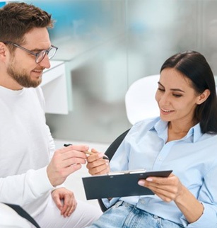 Dental patient preparing to sign paperwork