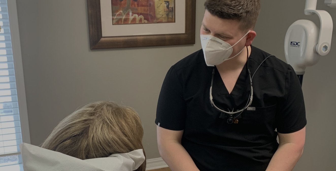 Dentist talking to patient in dental chair