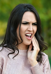 woman holding her mouth in pain in Garfield