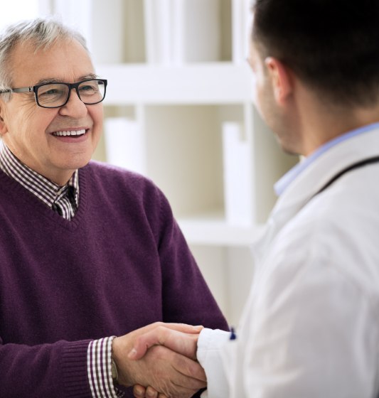 Dental patient shaking hands with dentist