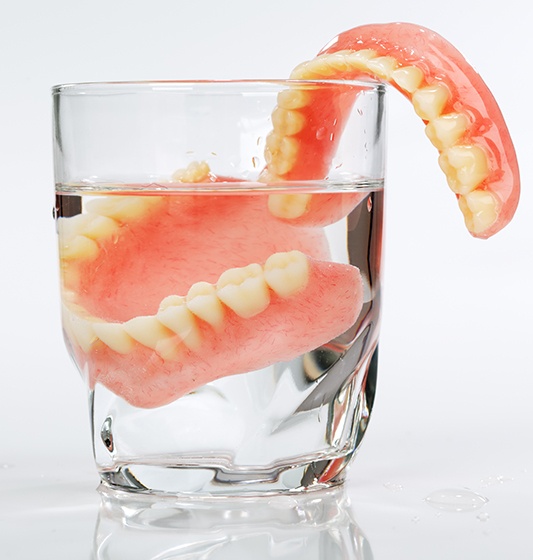 Set of dentures in glass of water