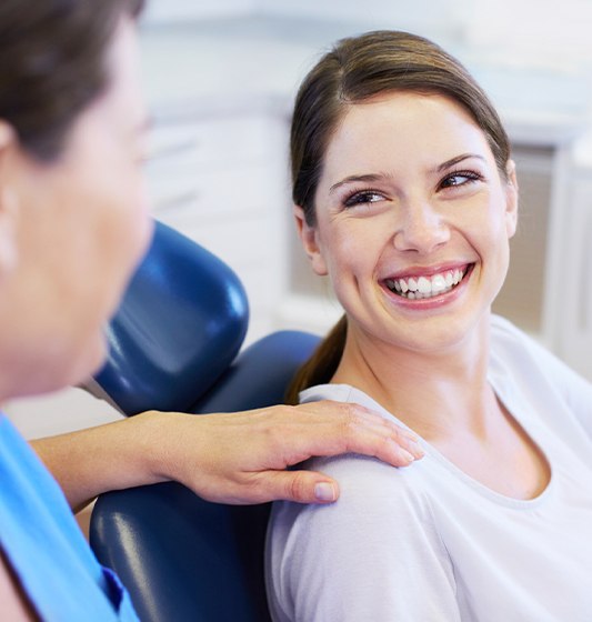 Woman smiling at dentist during preventive dentistry checkup