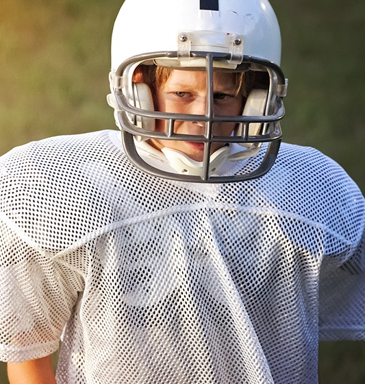Teen boy in football gear with athletic mouthguard