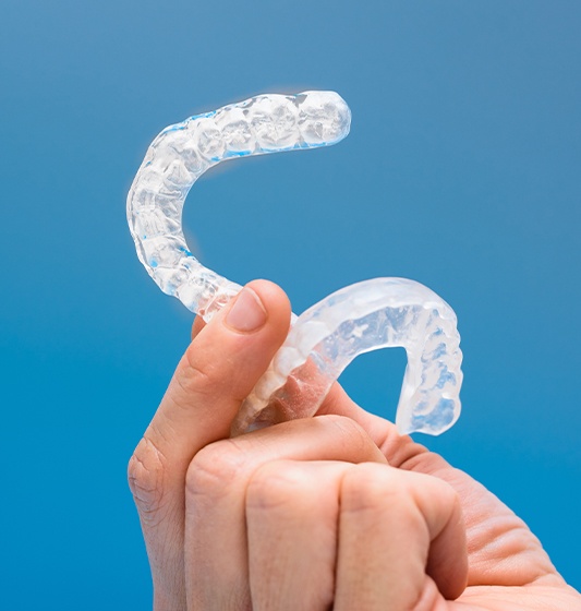 Hand holding clear nightguard for bruxism