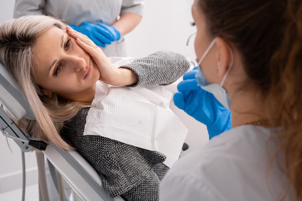 Woman with toothache visiting emergency dentist