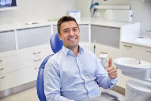 Man holding thumbs up while at the dentist